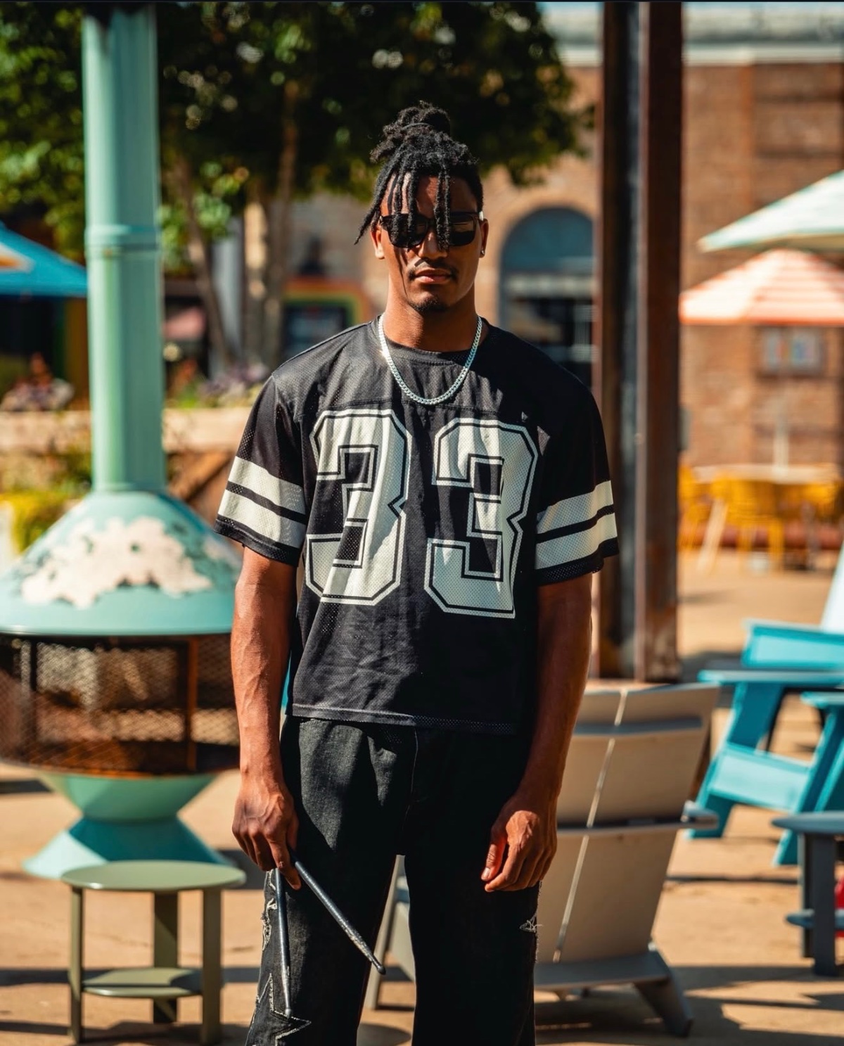 Jaywill Williams standing outdoors holding a drumstick, wearing a number 33 jersey