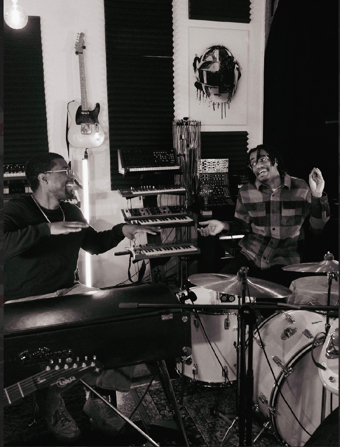 Jaywill laughing with a collaborator behind the kit during a studio session